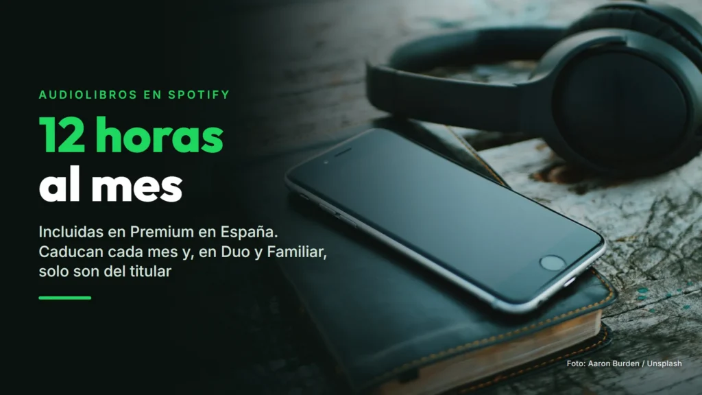 Un móvil sobre un libro con unos auriculares al lado, en una mesa de madera, junto al texto «Audiolibros en Spotify. 12 horas al mes. Incluidas en Premium en España. Caducan cada mes y, en Duo y Familiar, solo son del titular»