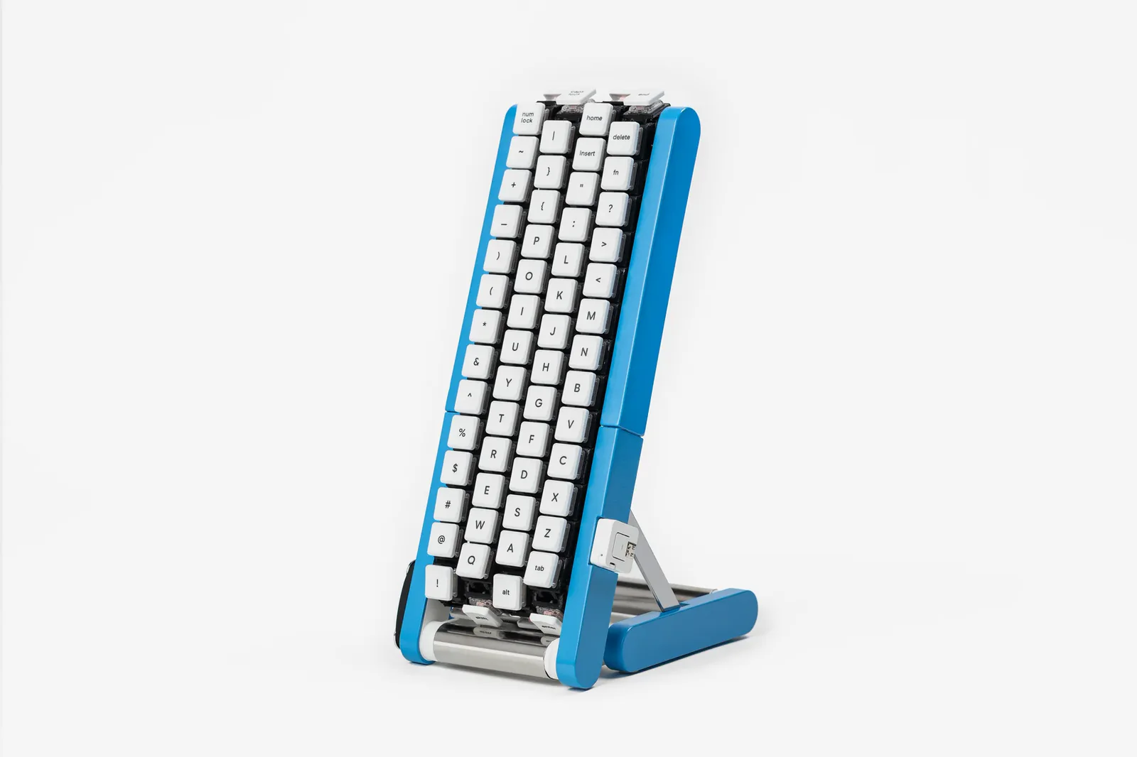 El Gboard kurukuru, un teclado vertical azul con cuatro columnas de teclas blancas sobre cintas y rodillos metálicos en la base