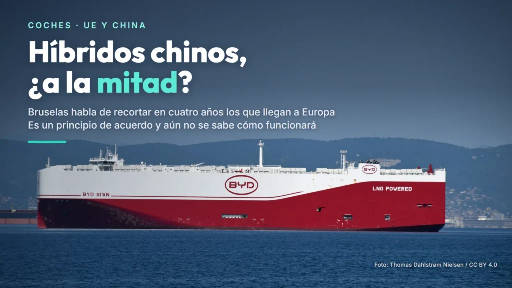 El barco de coches BYD Xi'an, blanco y rojo, en el mar frente a Koper (Eslovenia), con el texto «Híbridos chinos, ¿a la mitad?»