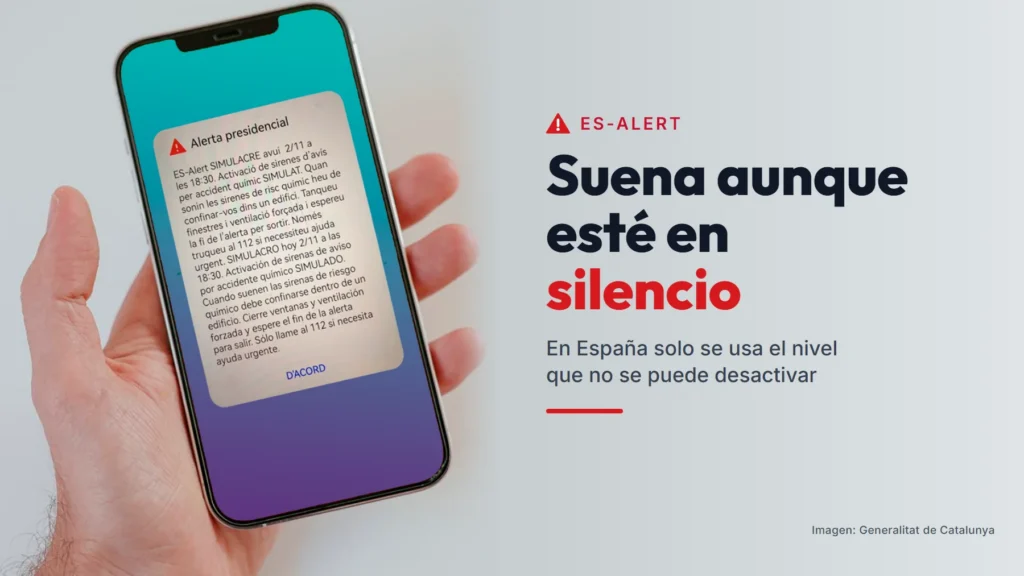 Mano con un móvil que muestra un simulacro de ES-Alert, con el texto «Suena aunque esté en silencio»