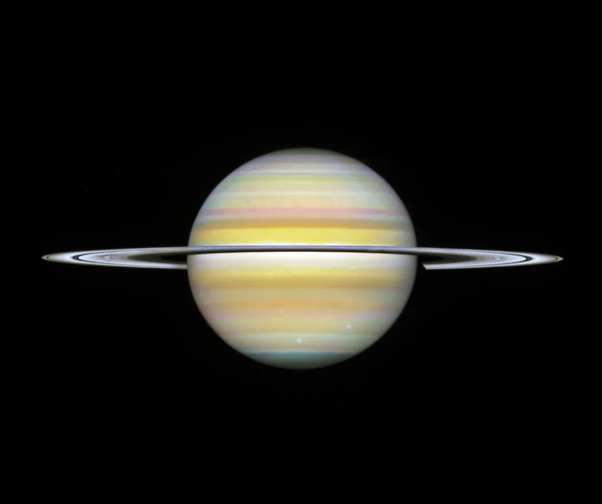Saturno fotografiado por el telescopio Hubble el 29 de agosto de 2025: un globo de bandas amarillentas y anaranjadas con los anillos vistos casi de canto, como una línea fina que lo cruza.