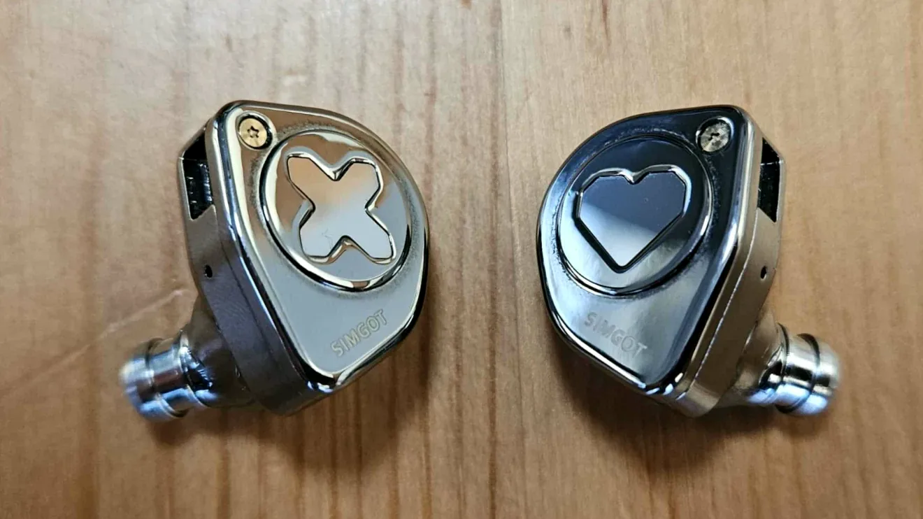Las dos cápsulas metálicas de los Simgot EW300, una con una equis y otra con un corazón, con las boquillas de acero de serie