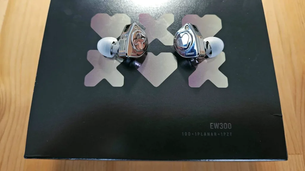 Los auriculares Simgot EW300 sobre su caja, con el rótulo EW300 1DD+1PLANAR+1PZT